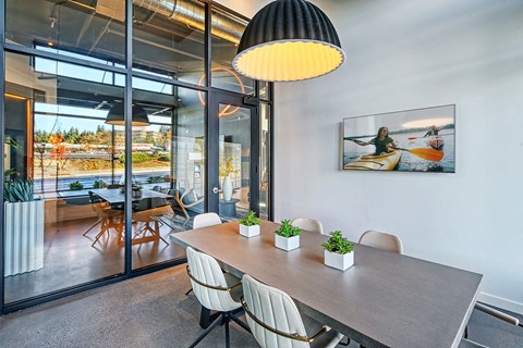 A modern dining room with a table, chairs, and a large window.