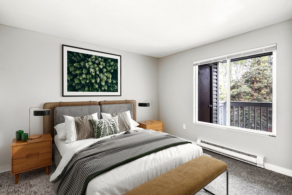 a bedroom with a large bed and two windows