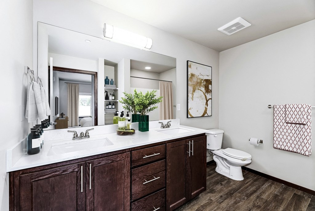 a bathroom with a large mirror and a toilet and a sink