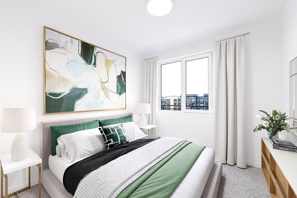 a bedroom with a green and white bed and a window