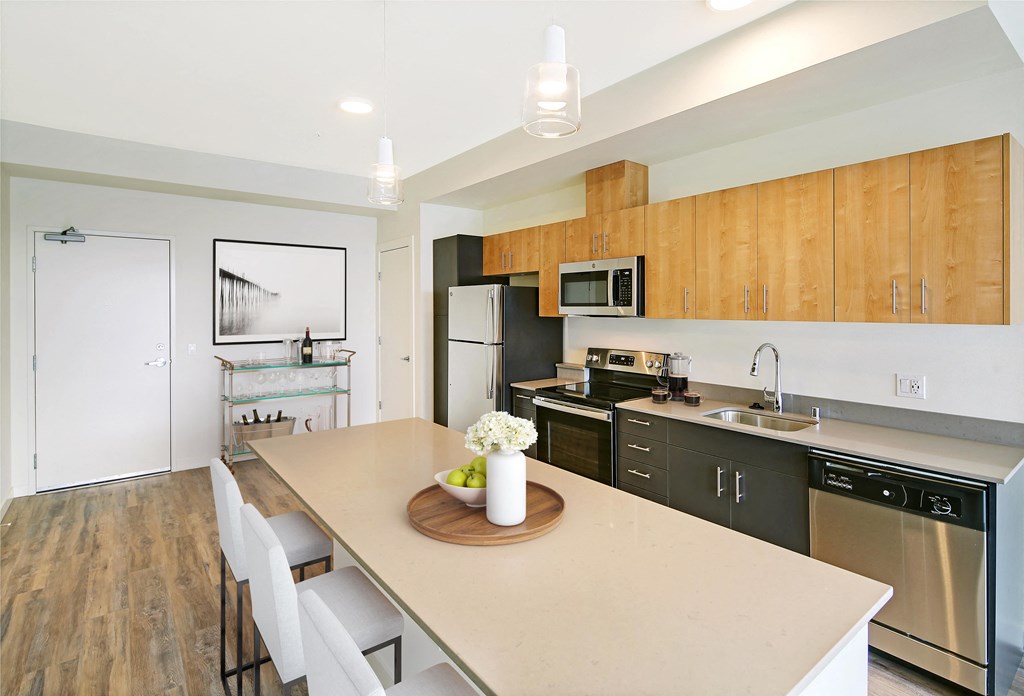 a kitchen with stainless steel appliances and wooden cabinets and a table with chairs