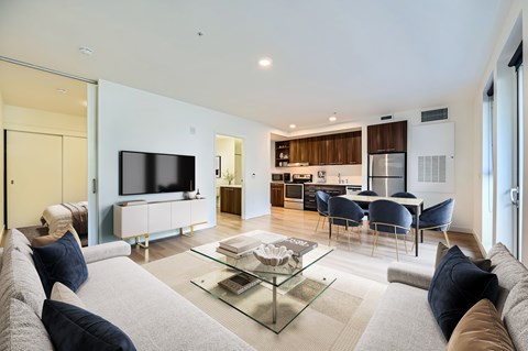 A modern living room with a grey sofa and a glass coffee table.
