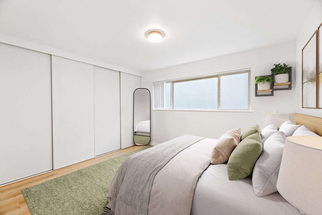 a bedroom with white walls and a bed with pillows