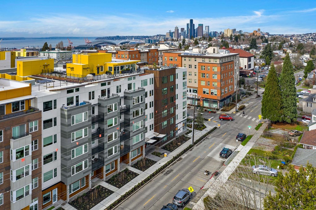 an aerial view of an apartment complex with the city in the background