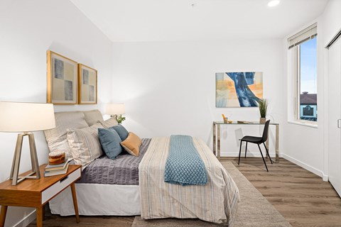 a bedroom with a bed and a desk and a window