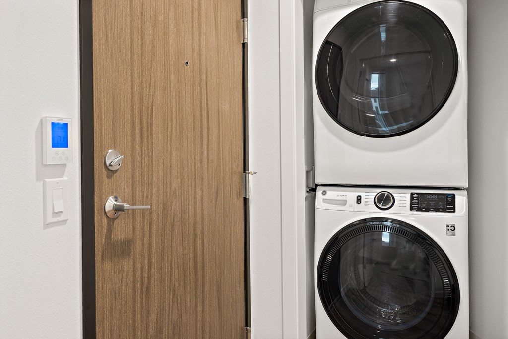 a white washer and dryer in a room next to a door