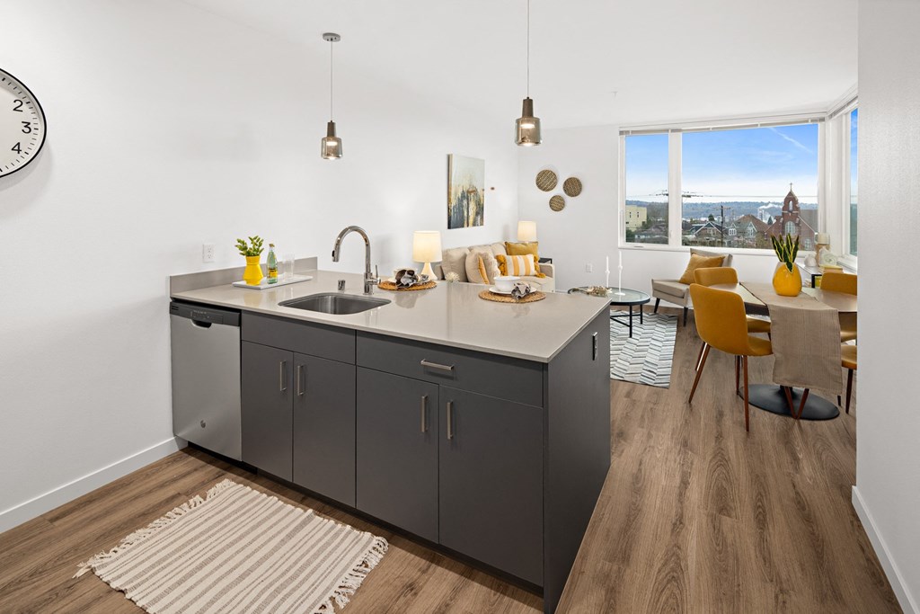 a kitchen and living room with a large window and a sink