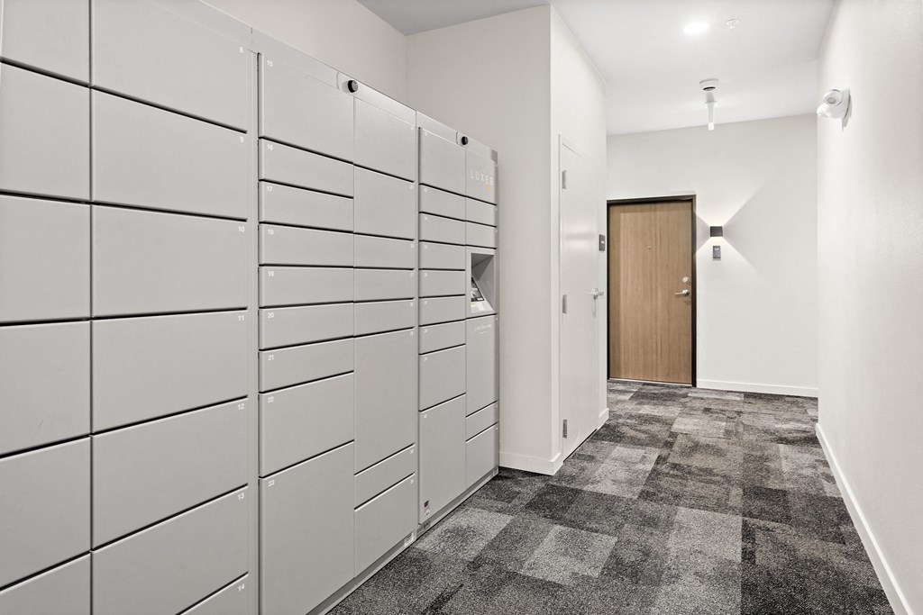 a row of white lockers in a room with a wooden door
