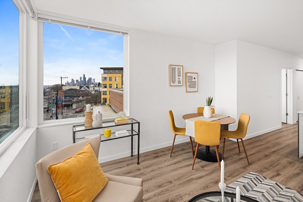 a living room with a table and chairs and a large window
