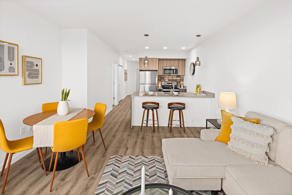 a living room and kitchen area with a couch and a table