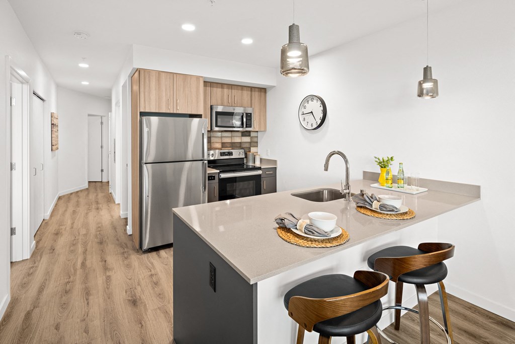 a kitchen with a island and a stainless steel refrigerator