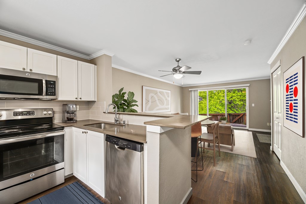 A kitchen with white cabinets and a stainless steel dishwasher.