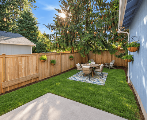 A backyard with a wooden fence and a table set for four.