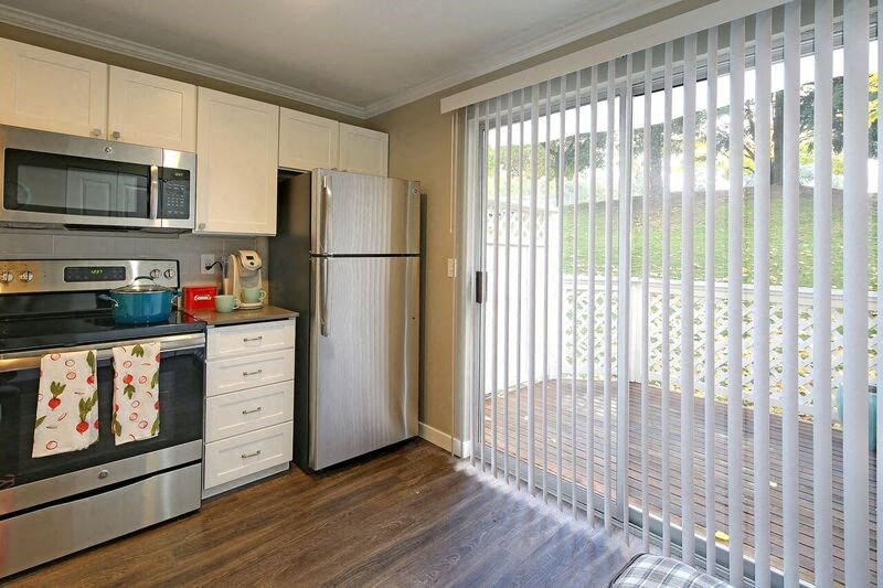 a kitchen with a sliding glass door and a refrigerator