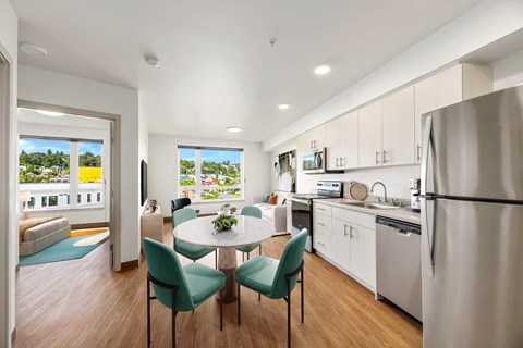 a kitchen and living room with a table and chairs