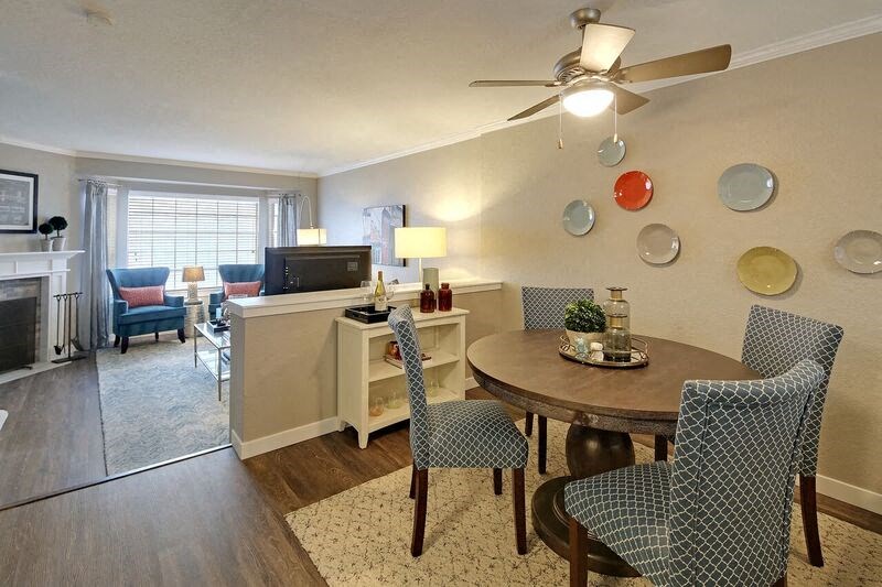 a living room and dining room with a table and chairs