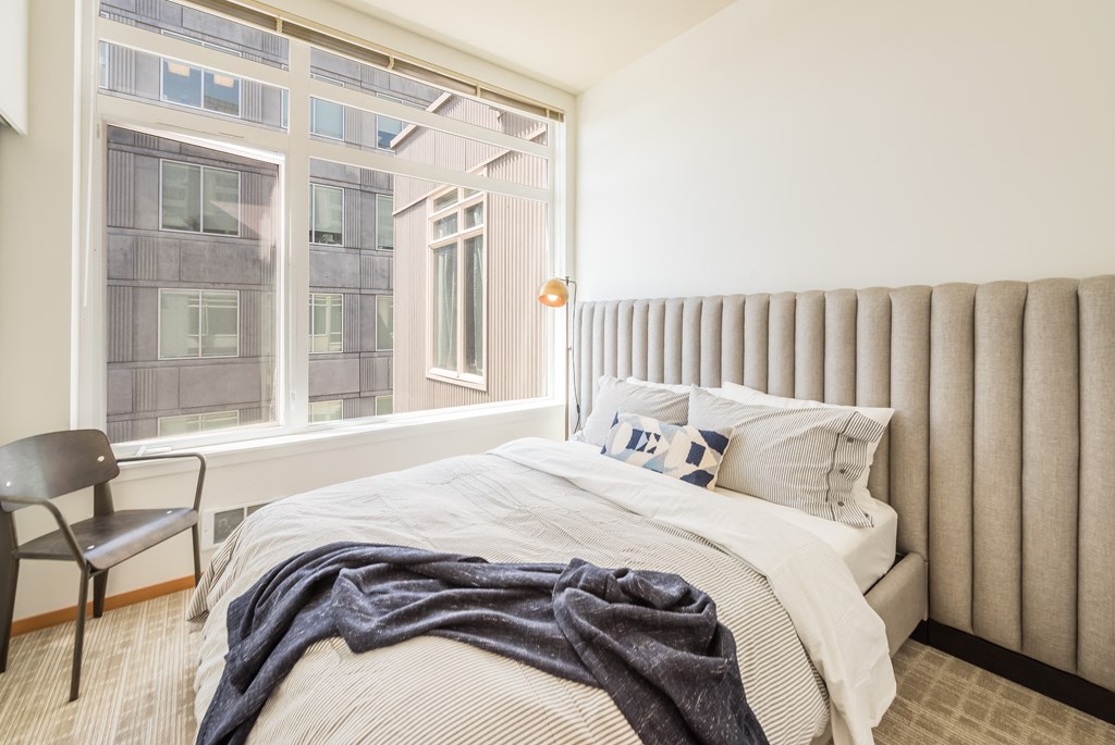 a bedroom with a bed and a large window