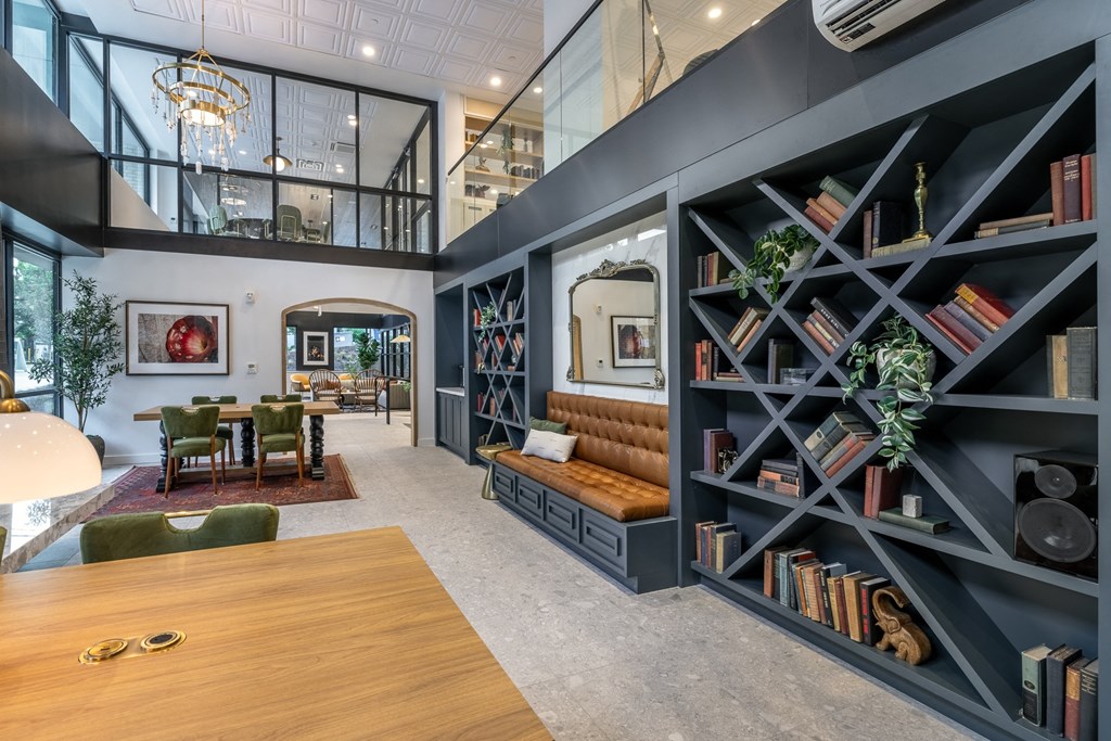 a living room with a large bookshelf and a dining room