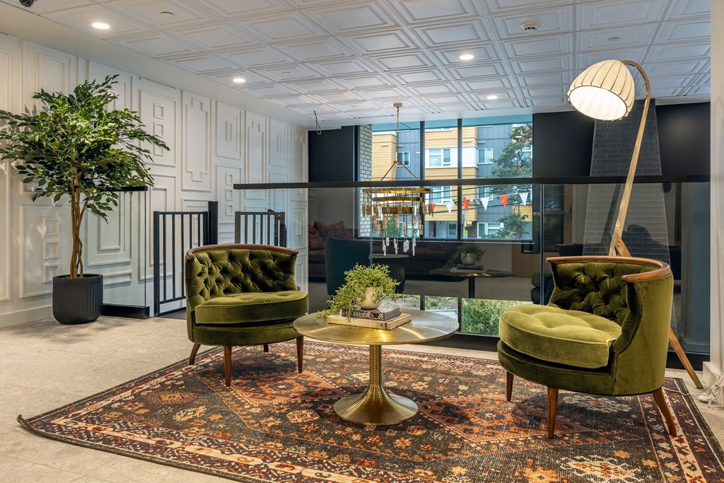 a living room with green chairs and a rug