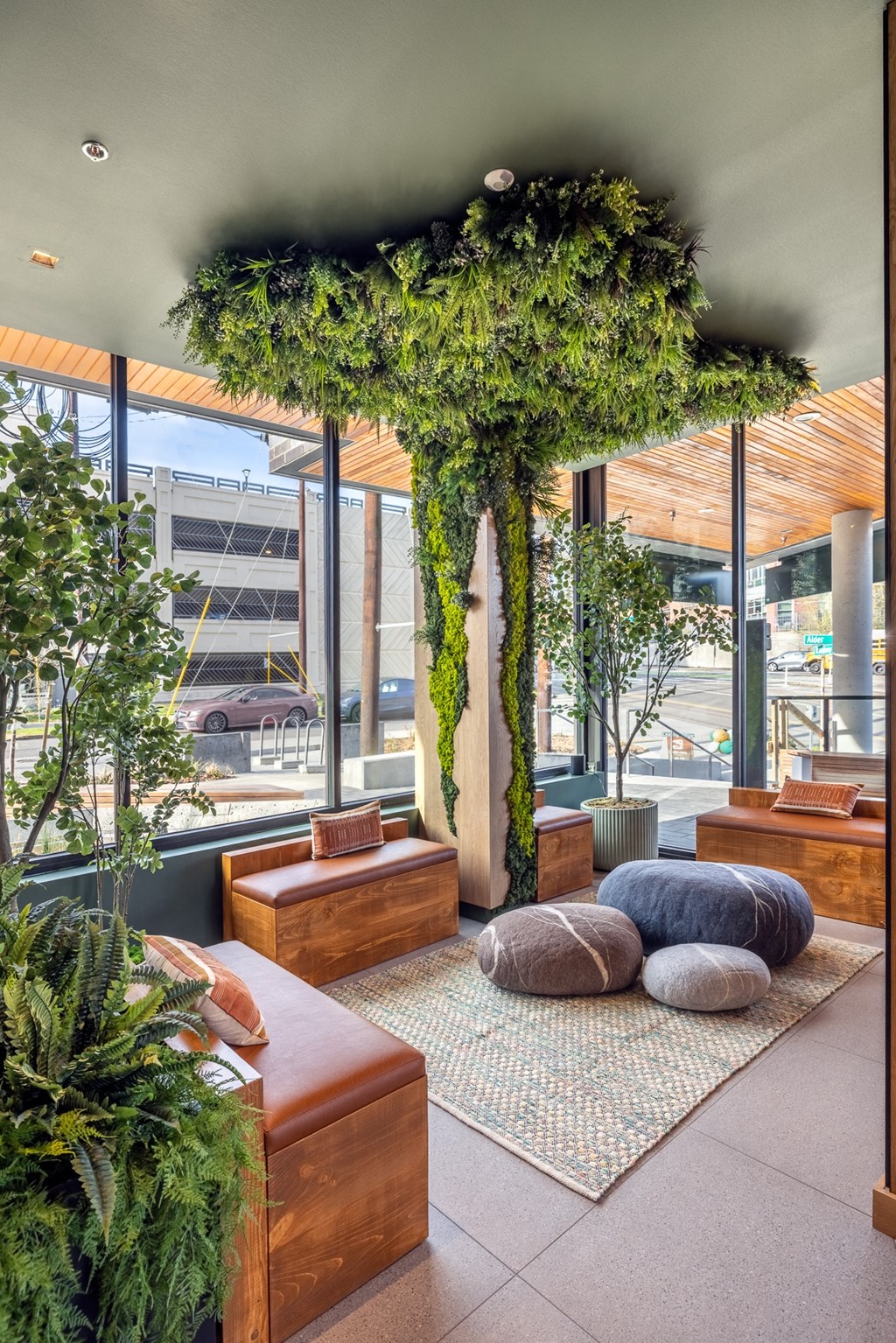 A living room with a tree in a planter and a couch.