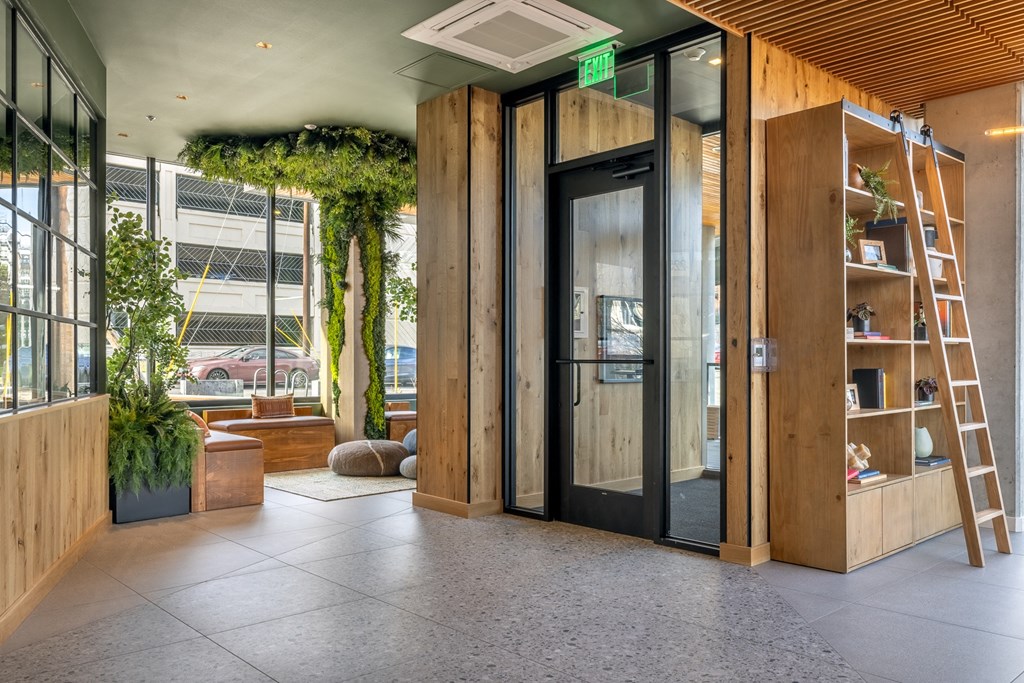 A room with a wooden floor and a green exit sign above the door.