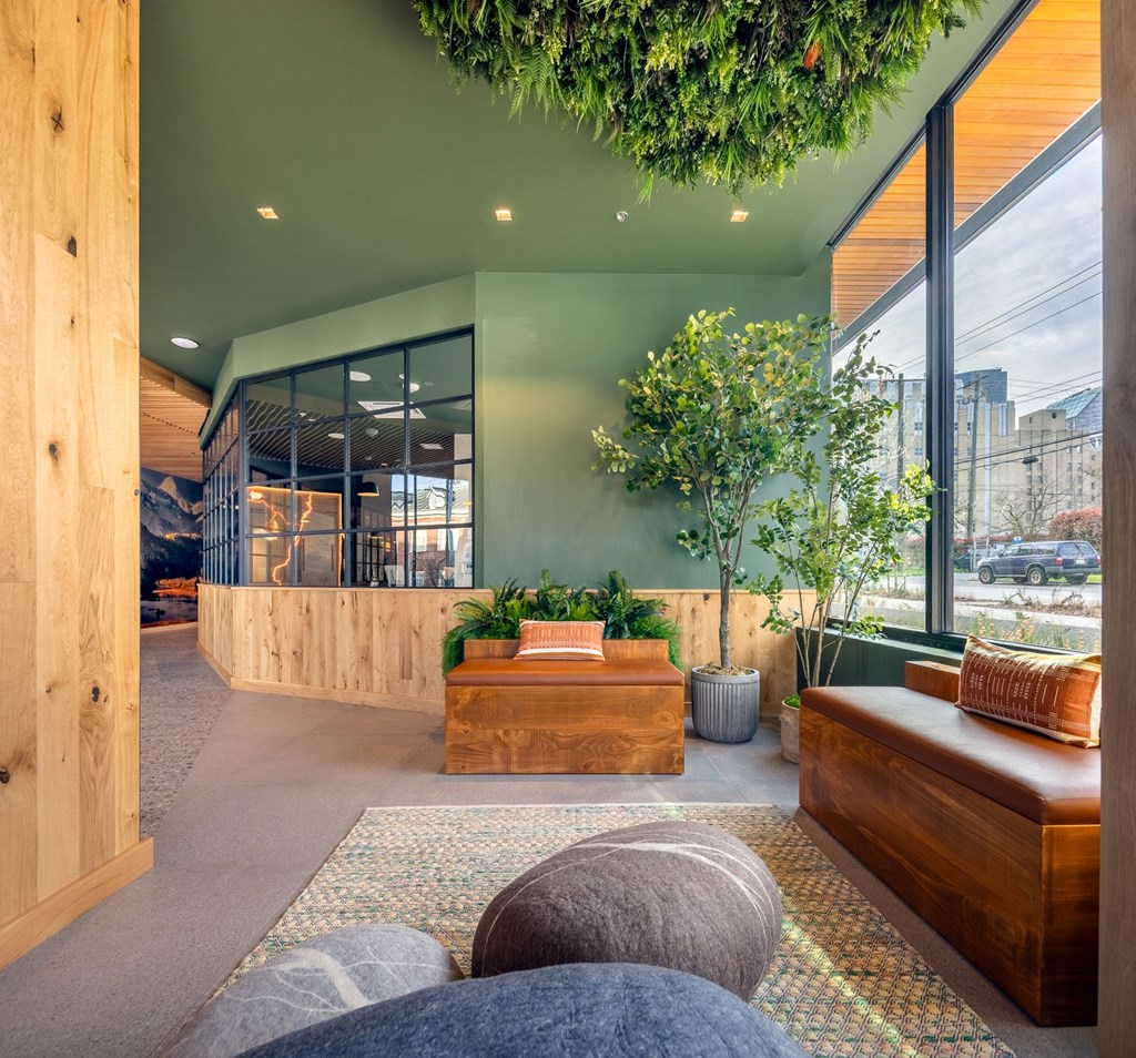 A modern living room with a green wall and wooden furniture.