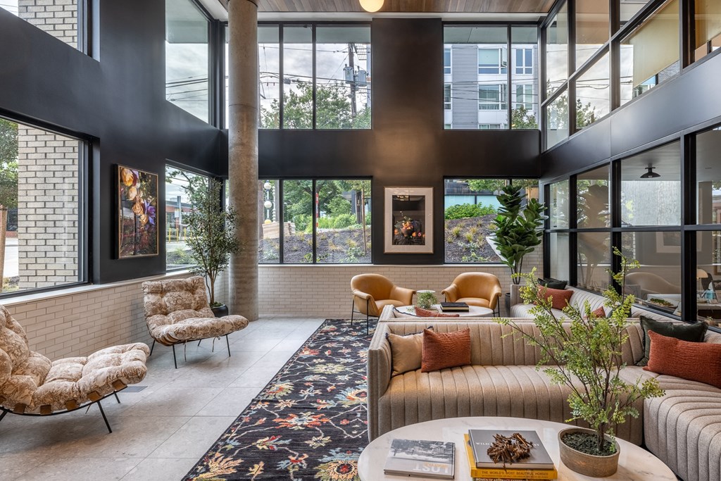 the lobby of a building with couches and chairs and large windows