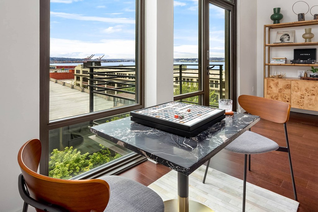 a dining room with a glass table and a view of the ocean