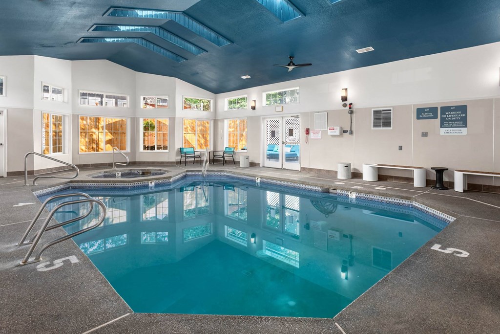 A large indoor swimming pool with a diving board.