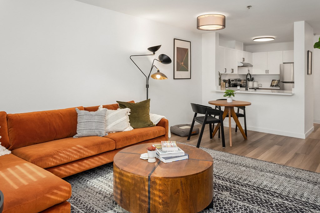a living room with a orange couch and a coffee table