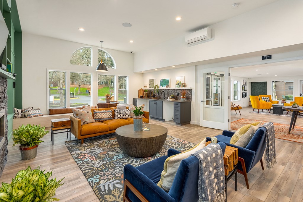 a living room with couches and chairs and a kitchen
