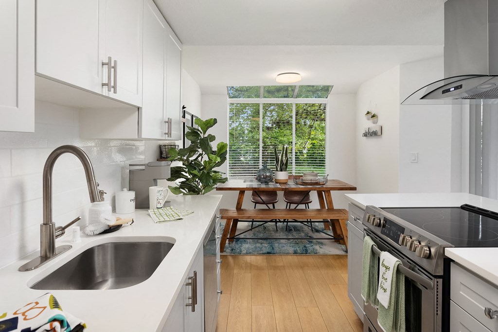a kitchen with white cabinets and a sink and a window