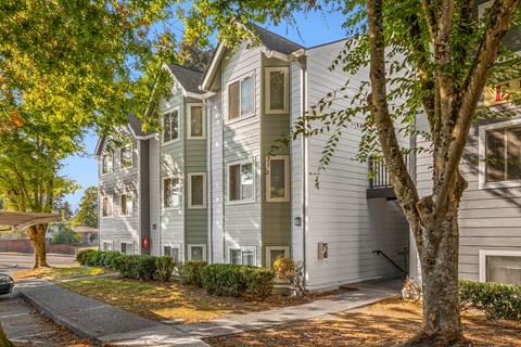 a green and white house with trees in front of it