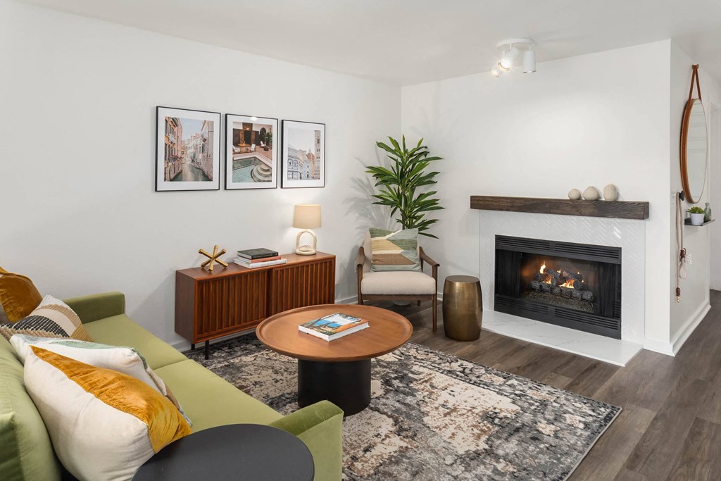 a living room with a green couch and a fireplace