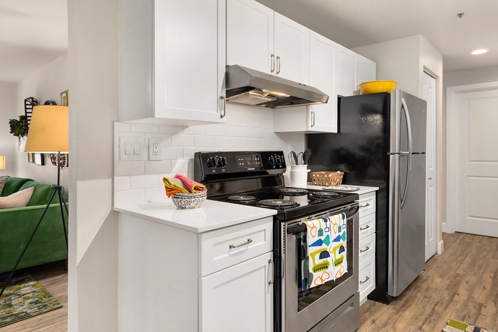 a white kitchen with stainless steel appliances and white cabinets