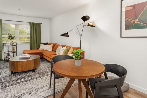 a living room with a orange couch and a table and chairs