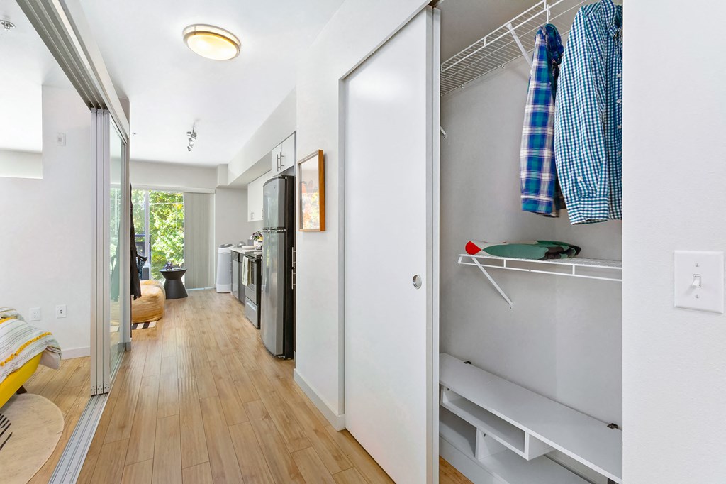 a hallway with a closet and a kitchen in a house
