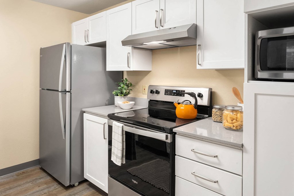 a kitchen with stainless steel appliances and white cabinets