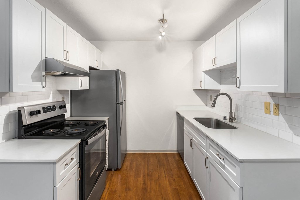 a kitchen with white cabinets and stainless steel appliances