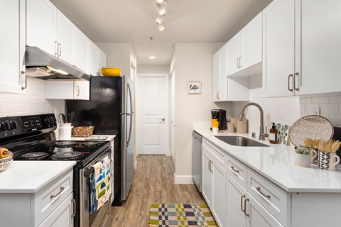 a kitchen with white cabinets and a black stove and refrigerator