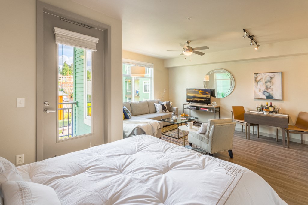 a bedroom with a bed and a living room with a couch