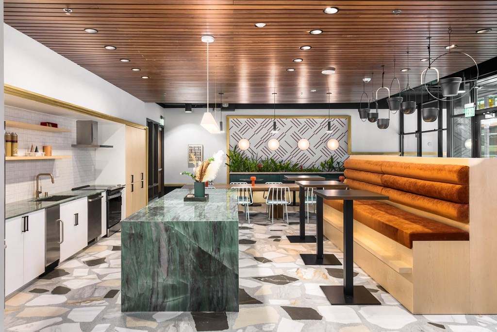 the lobby or reception area of a hotel with a kitchen and a dining table