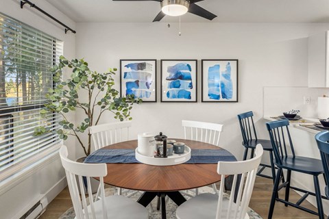 a dining room with a table and chairs and a window