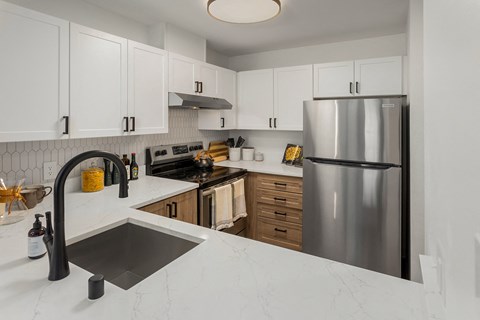 a large kitchen with stainless steel appliances and white countertops