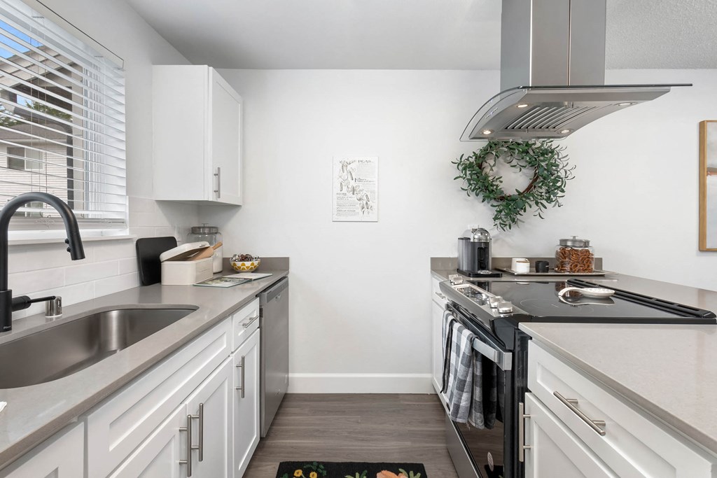 a kitchen with white cabinets and a stainless steel sink