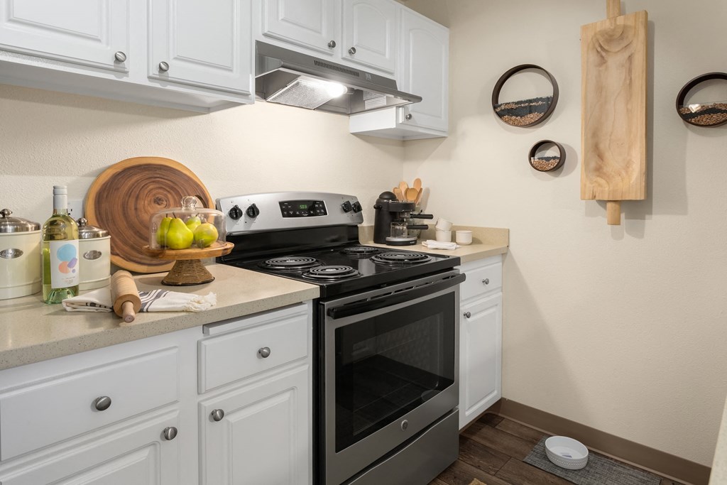 a kitchen with white cabinets and a stove and a microwave