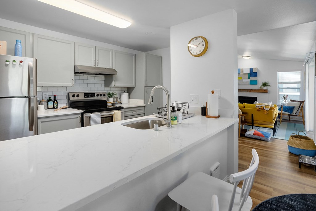 a kitchen with a white counter top and a sink