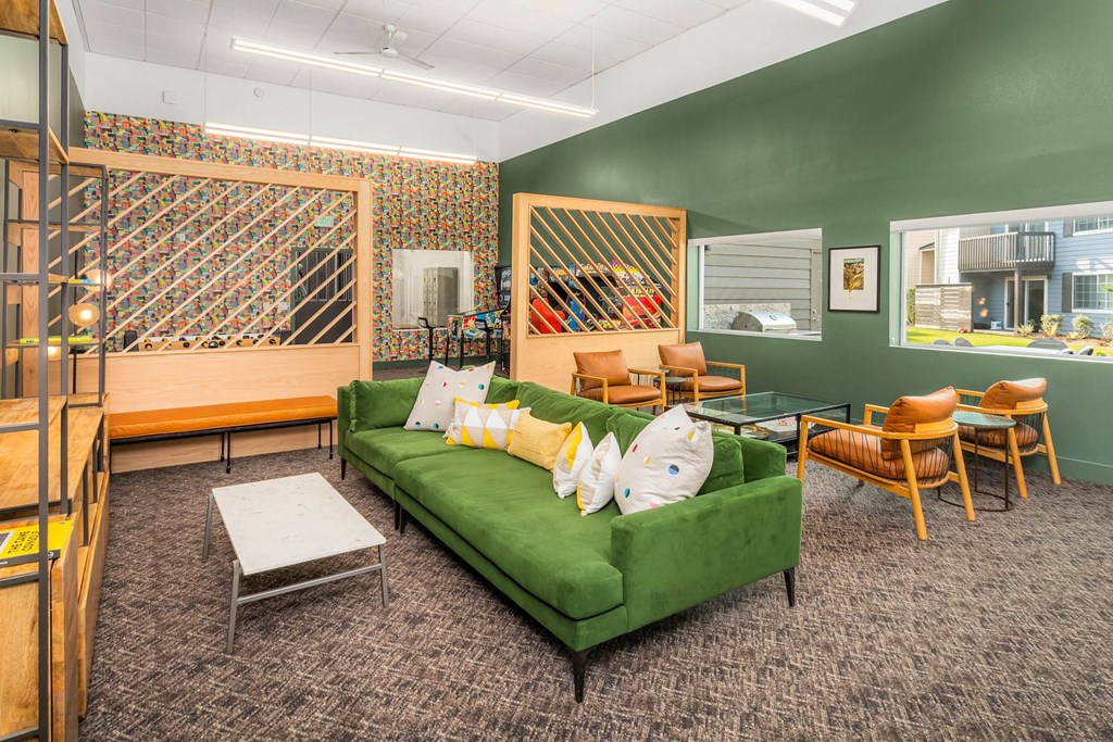 a living room with a green couch and chairs