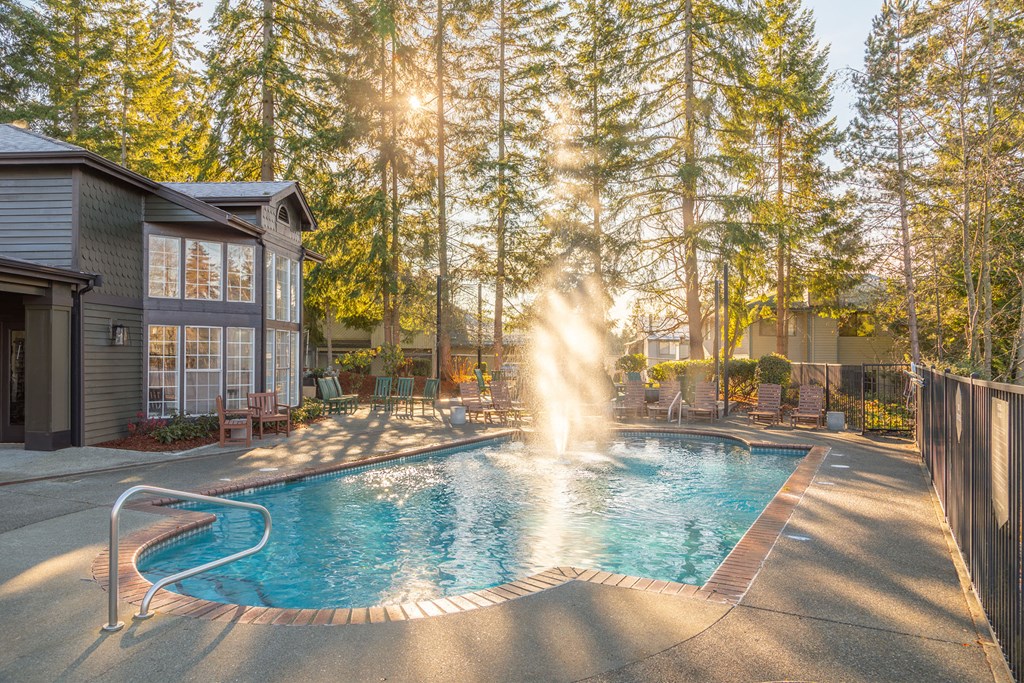 a swimming pool with a fountain in front of a house