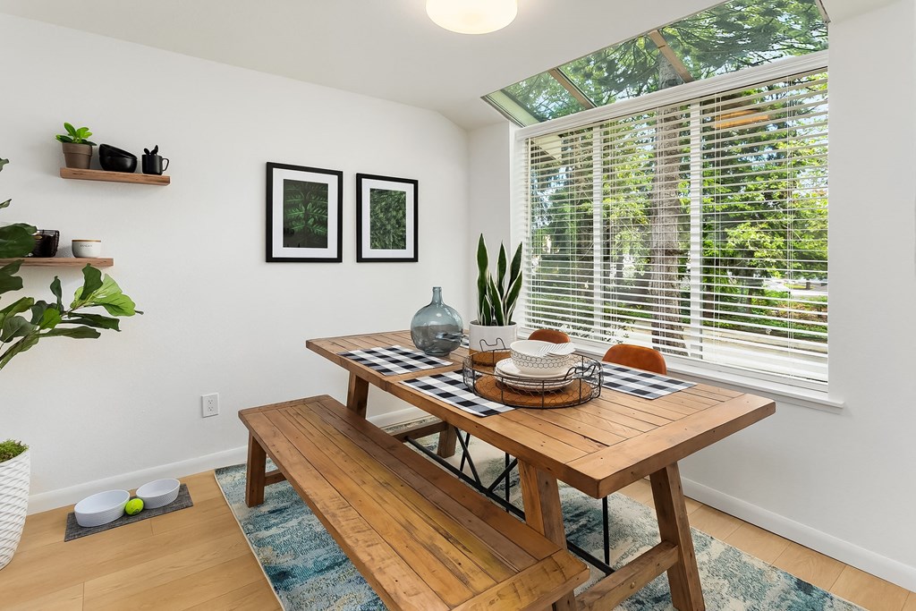 a dining room with a wooden table and a large window